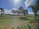 Lush green golf course view showcases the beautiful landscaping behind the screened enclosure at 15618 Castle Park Ter, Lakewood Ranch, FL 34202