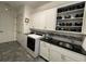 Well-organized laundry room with modern washer, dryer, granite countertops, tile backsplash, and ample storage at 15618 Castle Park Ter, Lakewood Ranch, FL 34202