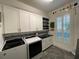 Functional laundry room with modern appliances, ample cabinetry, and natural light from the window at 15618 Castle Park Ter, Lakewood Ranch, FL 34202