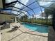 Screened pool with a spa and outdoor kitchen, set against a backdrop of green lawn at 15618 Castle Park Ter, Lakewood Ranch, FL 34202