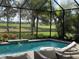 Enclosed pool and spa with golf course view, palm trees, and wicker chairs providing comfortable seating options at 15618 Castle Park Ter, Lakewood Ranch, FL 34202