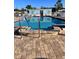 Community pool with an umbrella and beach mural for a vacation-at-home feel at 68 4Th Ave, Venice, FL 34285