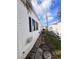 Exterior side of house with pathway, A/C unit, vinyl siding, and gravel at 68 4Th Ave, Venice, FL 34285