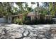 Light peach house with white trim, surrounded by lush tropical landscaping at 144 Garden Ln, Sarasota, FL 34242