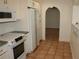 White kitchen with stainless steel appliances and terracotta floor at 144 Garden Ln, Sarasota, FL 34242