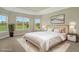 Luxurious main bedroom with a king-size bed and large windows with garden views at 15625 San Lazzaro Ave, Bradenton, FL 34211