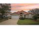 Tan house with orange roof, white garage door, and landscaped lawn at 5296 White Sand Ne Cir, St Petersburg, FL 33703