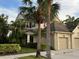 Tan two-story townhome with attached garage and palm trees in front at 7937 St Simons St # 7937, University Park, FL 34201