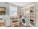 Small laundry area with washer, dryer, and built-in shelving at 114 31St St, Holmes Beach, FL 34217