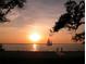 Tranquil sunset over the water with a sailboat at 114 31St St, Holmes Beach, FL 34217