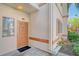 Condo building entrance with orange door and landscaping at 3956 Mediterranea Cir # 412, Sarasota, FL 34233