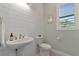 Powder room with shiplap walls and white pedestal sink at 4950 Kiva Cir, Bradenton, FL 34211