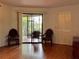 Living room with wood-look floors, comfortable seating, and a sliding door leading to the screened lanai at 6447 Egret Ln # 413, Bradenton, FL 34210