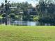 Scenic pond view with lush landscaping and multi-story condo buildings in the background on a clear, sunny day at 6447 Egret Ln # 413, Bradenton, FL 34210