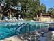 Sparkling blue swimming pool surrounded by lounge chairs and mature trees offering shade for relaxation at 6447 Egret Ln # 413, Bradenton, FL 34210