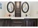 Double vanity bathroom with dark wood cabinets and oval mirrors at 117 Hillcrest Dr, Bradenton, FL 34209