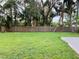 Spacious backyard with a large lawn and wooden fence at 2549 Arapaho St, Sarasota, FL 34231