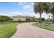 Elegant home with a curving brick driveway and lush landscaping at 8480 Big Buck Ln, Sarasota, FL 34240