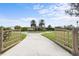 Long driveway leading to a two-story home with decorative gates at 8480 Big Buck Ln, Sarasota, FL 34240