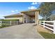 Spacious garage with open door, concrete driveway, and white fence at 8480 Big Buck Ln, Sarasota, FL 34240