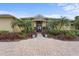 Inviting house entrance with brick walkway, lush landscaping, and palm trees at 8480 Big Buck Ln, Sarasota, FL 34240