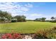 Spacious grassy backyard with neatly landscaped borders and distant trees at 8480 Big Buck Ln, Sarasota, FL 34240