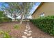 Stone path meanders through a side yard with mature trees and a hedge at 8480 Big Buck Ln, Sarasota, FL 34240