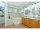 Bathroom with soaking tub, double vanity, and glass block windows at 2629 Rolling Rd, North Port, FL 34288