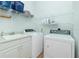 Bright laundry room with washer, dryer, and shelving at 2629 Rolling Rd, North Port, FL 34288