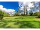 Spacious lot with lush green grass and mature trees at 2629 Rolling Rd, North Port, FL 34288