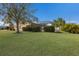 Landscaped backyard with lush lawn and screened pool area at 4135 Dover E Dr, Bradenton, FL 34203