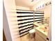 Cozy bathroom featuring a shower-tub combo with a modern black-and-white striped shower curtain at 5132 36Th W St, Bradenton, FL 34210