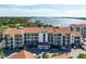 Aerial view of waterfront condo building with parking and landscaping at 1624 Stickney Point Rd # 401, Sarasota, FL 34231