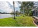 Calm lake view with a grassy backyard and palm trees at 455 Park Trace Blvd, Osprey, FL 34229