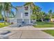 Two-story house with gray double garage doors, white siding, and palm trees at 602 84Th Nw St, Bradenton, FL 34209