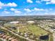 Aerial shot of a neighborhood with houses and a large green park with soccer fields and ponds at 14847 Skip Jack Loop, Lakewood Ranch, FL 34202