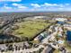 Aerial view of townhomes near a park featuring a large soccer field and a walking path with a lake at 14847 Skip Jack Loop, Lakewood Ranch, FL 34202