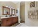 A bright bathroom featuring double vanities, framed mirrors, and tile flooring at 14847 Skip Jack Loop, Lakewood Ranch, FL 34202