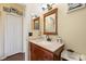 Bathroom features a wood vanity, neutral walls, and wood floors at 14847 Skip Jack Loop, Lakewood Ranch, FL 34202