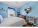 Bedroom features blue walls, wood floors, and a mounted television at 14847 Skip Jack Loop, Lakewood Ranch, FL 34202