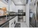 Well-equipped kitchen featuring stainless steel appliances, white cabinets, mosaic tile backsplash, and white wood floor at 14847 Skip Jack Loop, Lakewood Ranch, FL 34202