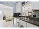 Modern kitchen with stainless steel sink, dark countertops, white cabinetry, and a pass-through to the living room at 14847 Skip Jack Loop, Lakewood Ranch, FL 34202