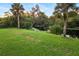 Green grassy backyard with pond and palm trees at 2129 Lorraine Dr, Port Charlotte, FL 33953