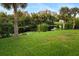 Spacious backyard with pond, lush grass, and palm trees at 2129 Lorraine Dr, Port Charlotte, FL 33953
