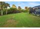 Large backyard with grassy area and screened pool at 2129 Lorraine Dr, Port Charlotte, FL 33953