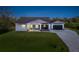 A charming house with gray siding, a gray roof, and a paver driveway at 2129 Lorraine Dr, Port Charlotte, FL 33953