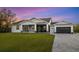 Modern home with gray siding, screened porch, and paver driveway at 2129 Lorraine Dr, Port Charlotte, FL 33953