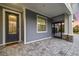 Covered porch with paver floor and modern front door at 2129 Lorraine Dr, Port Charlotte, FL 33953