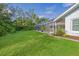 Landscaped backyard with lush lawn and screened enclosure at 3017 Wilderness E Blvd, Parrish, FL 34219