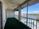Screened balcony featuring green carpet and an outdoor ceiling fan with waterfront views at 3993 Lake Bayshore Dr # F513, Bradenton, FL 34205